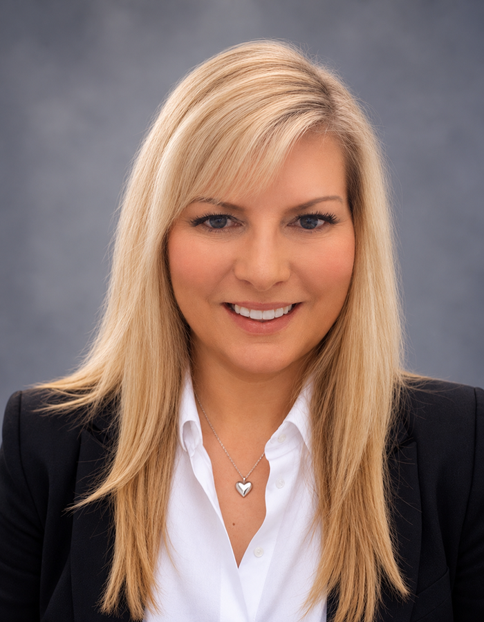 Woman, long blonde hair, in business attire smiling
